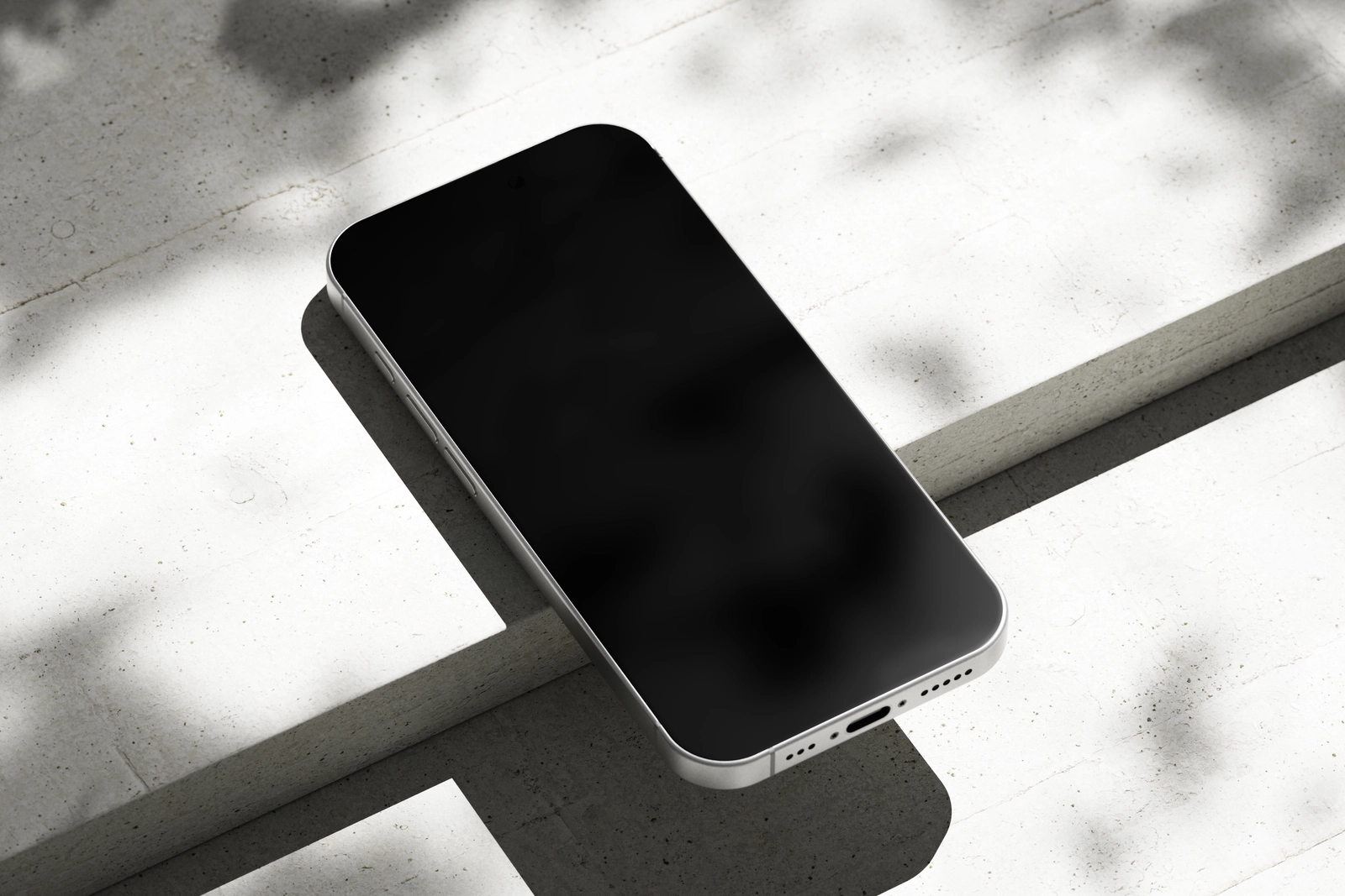Free iPhone 16 Pro Mockup on Bright Concrete Surface with Shadows